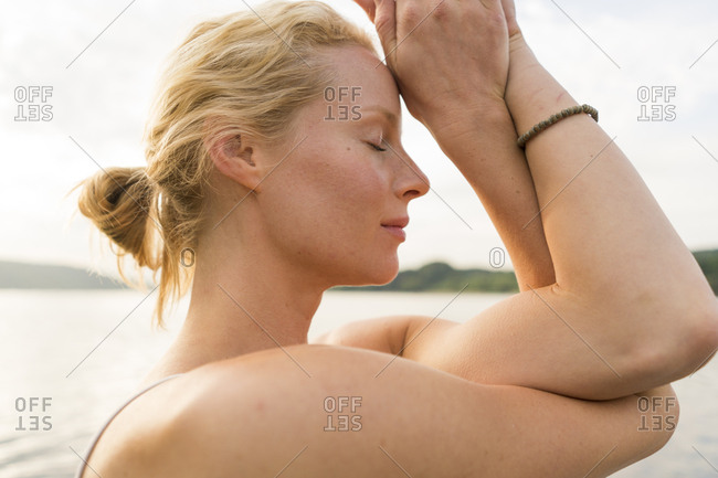 Close-up of young woman with closed eyes at a lake