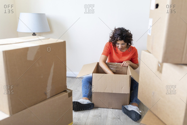 Woman moving into new looking into cardboard box