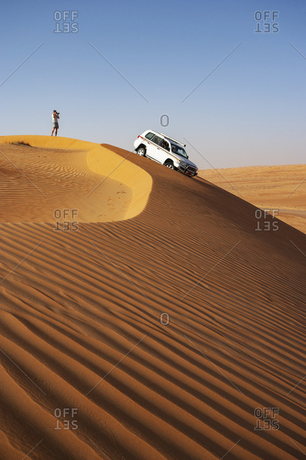 Man with off-road vehicle- taking pictures in the desert- Wahiba Sands- Oman