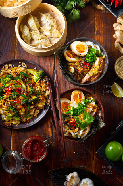 Asian cuisine dishes: pork ramen with soy-marinated eggs, vegetarian fried rice and gyoza dumplings served in a bamboo steamer