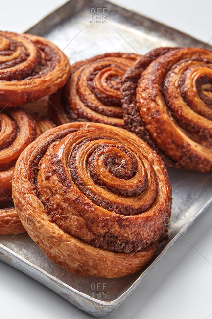 Freshly baked cinnamon buns with spices on the metal sheet. Sweet homemade pastry christmas baking. Close-up.