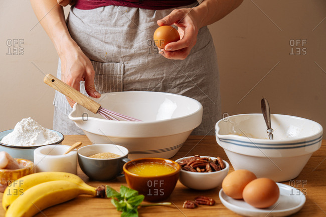 Woman holding an egg while preparing a recipe