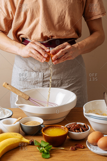 Chef cracking an egg while preparing a recipe