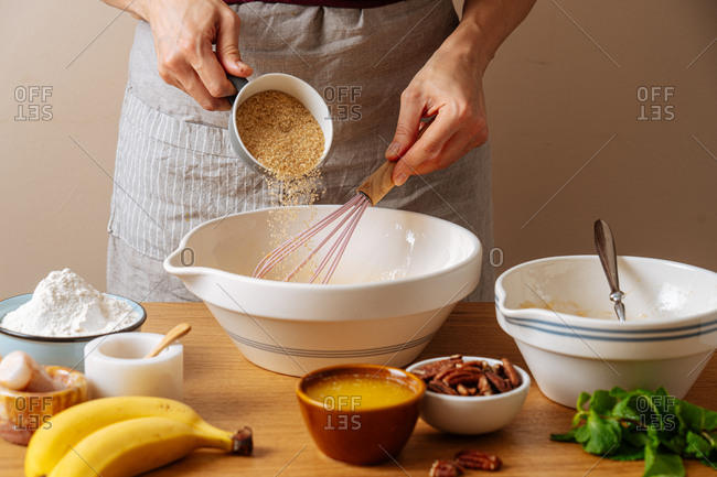 Chef adding sugar into a bowl while preparing a recipe