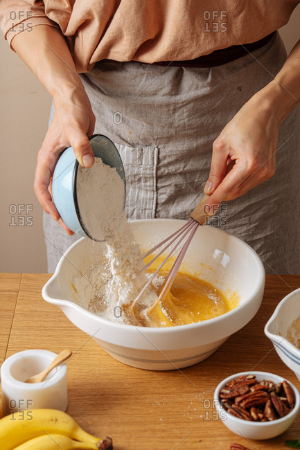 Chef mixing flour into a bowl while preparing a recipe