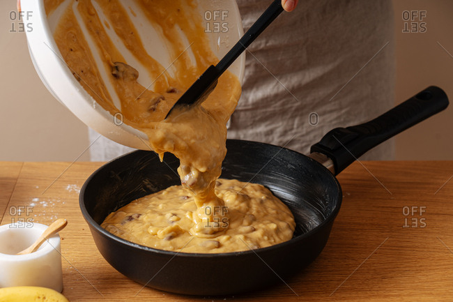 Chef pouring mixed ingredients into a skillet