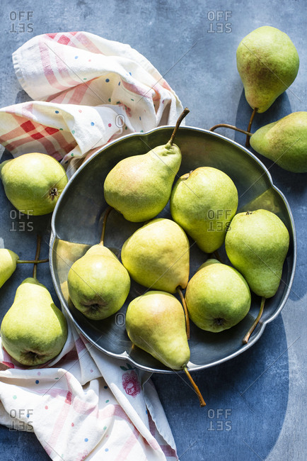 Still life of pears in metal bowl in sunlight