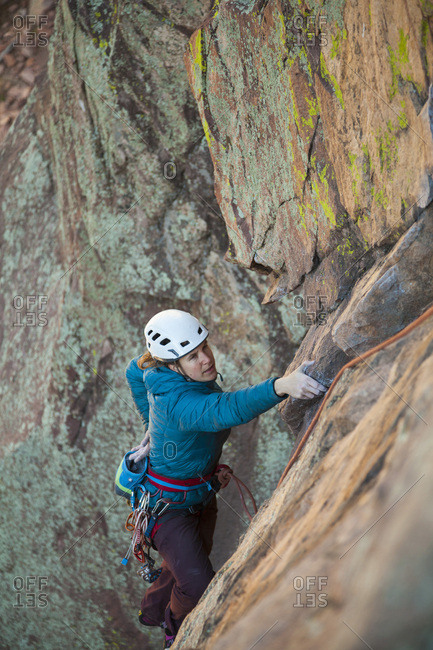 Woman chalks hands while rock climbing in Eldorado Canyon, Colorado