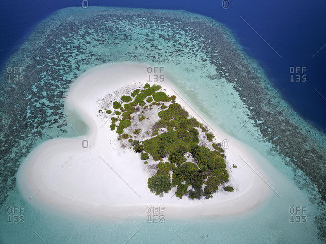 Heart-shaped, uninhabited palm island with sandy beach, offshore coral reef, Ari atoll, Indian Ocean, Maldives, Asia
