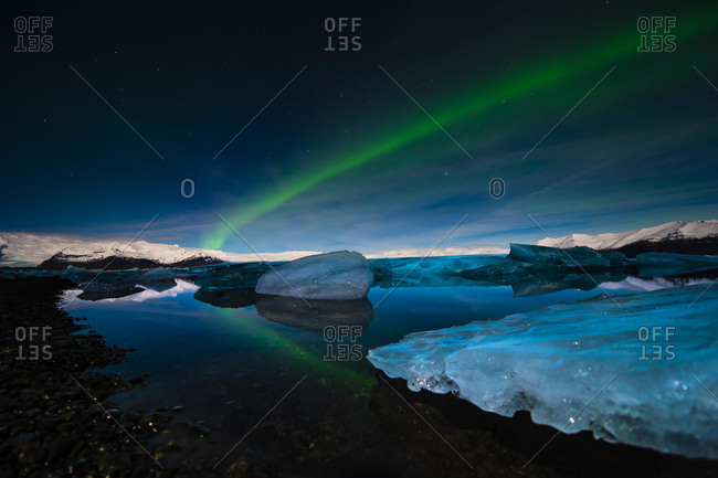 Chunks of ice in the water at the blue hour with polar lights, Jokulsarlon lake, Vik, Iceland, Europe