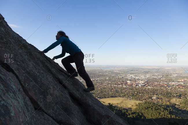 Woman climbs second flatiron without rope above boulder, colorado