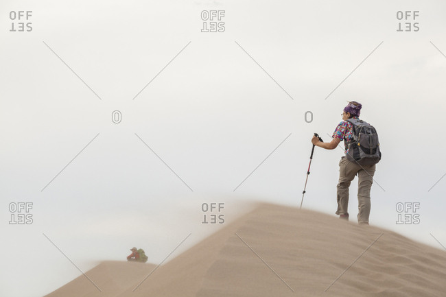 Senior couple on windswept summit of dune