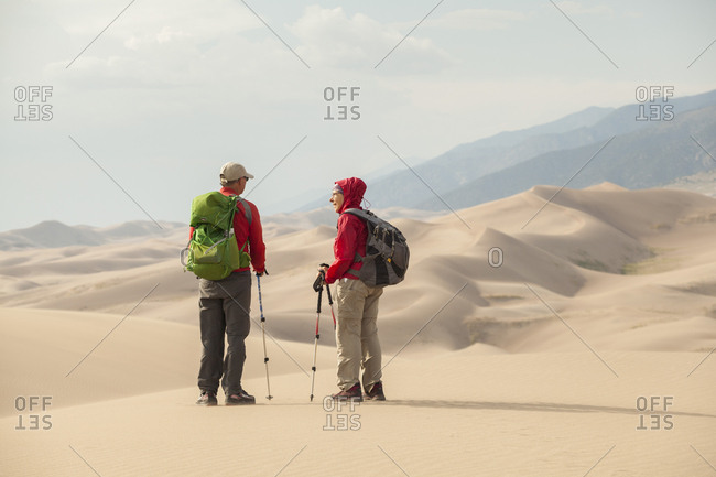 United States, Colorado, Great Sand Dunes National Park - August 9, 2018: Senior couple talk and enjoy view of sand dunes