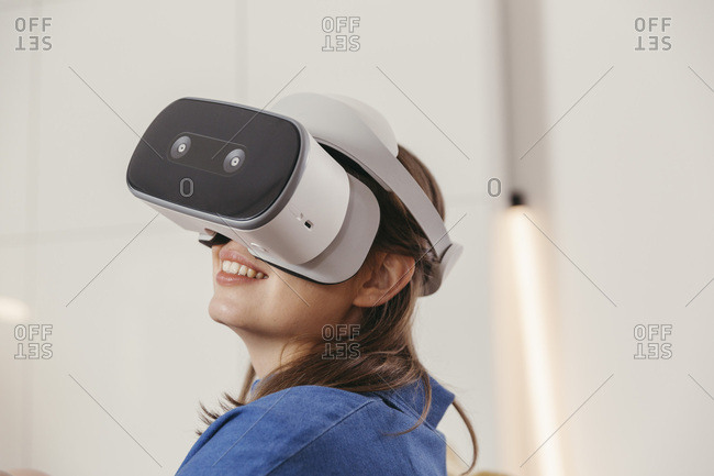 Young woman using VR glasses at home
