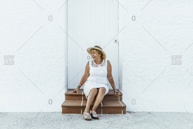 Senior tourist sitting on stoop in a village- El Roc de Sant Gaieta- Spain