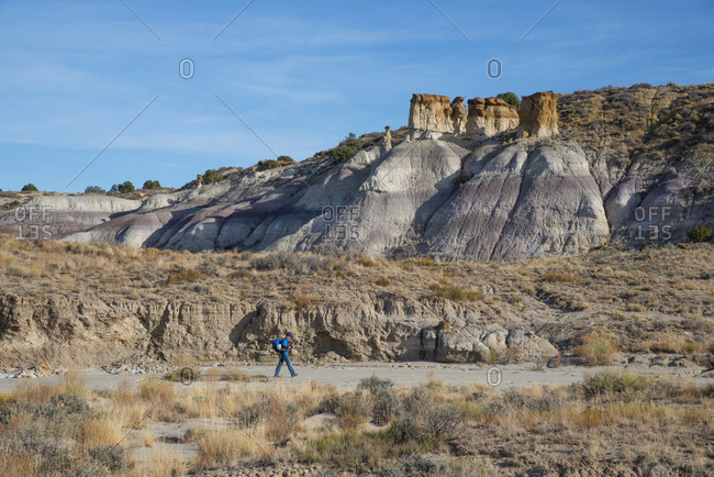 Man hiking through in Bisti/De-Na-Zin Wilderness in New Mexico
