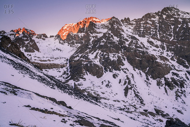 Tranquil rocky slopes of mountain chain with snowy peaks in daylight