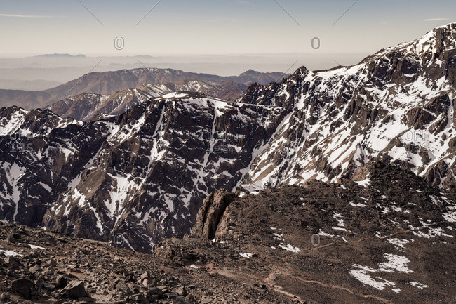 Tranquil rocky slopes of mountain chain with snowy peaks in daylight