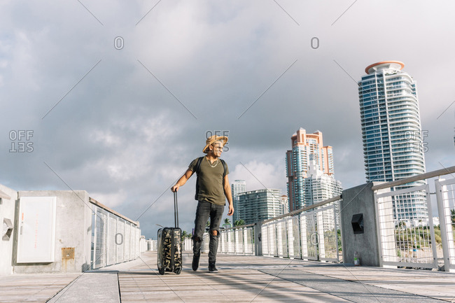 Traveler hipster man wearing a hat With A Suitcase. Travel Lifestyle and Adventure concept.