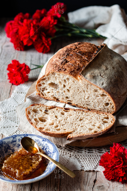 Pieces of tasty fresh bread falling on napkin on table against black background