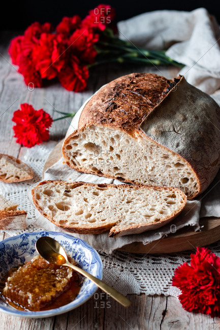 Pieces of tasty fresh bread falling on napkin on table against black background