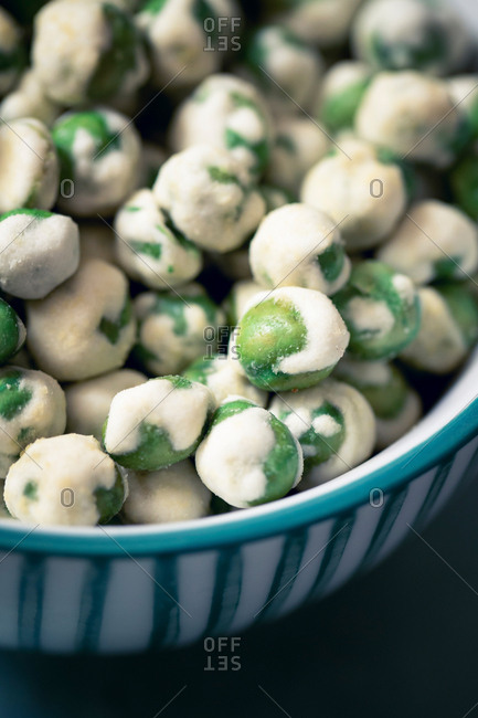 A closeup of a bowl of wasabi peas, a spicy Japanese savory snack of dried green peas with a wasabi horseradish coating.