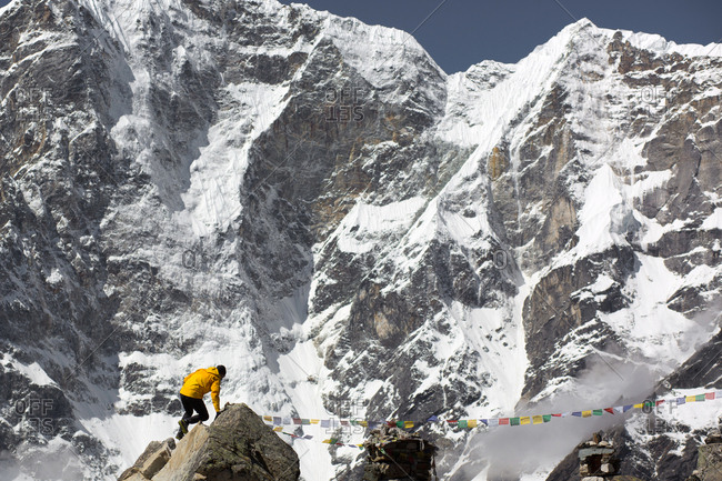 A man scrambles under the mountains of the Himalayas.