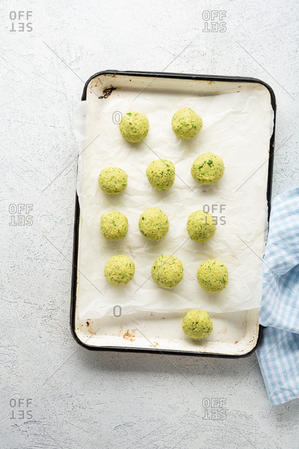 Raw falafel balls on baking sheet