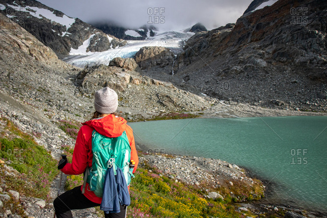 Rear view of hiker girl against glacier and mountain