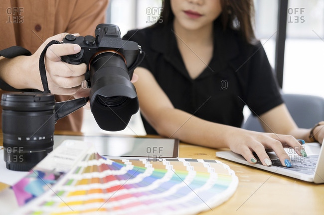 Photo artist and graphic designer selecting pictures from camera