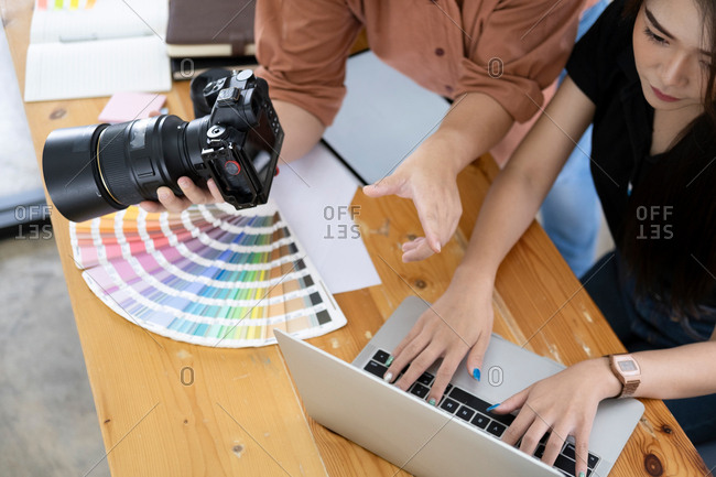 Photo artist and graphic designer selecting pictures from camera