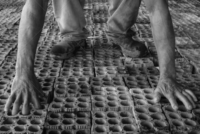 Worker picks bricks in a brick yard