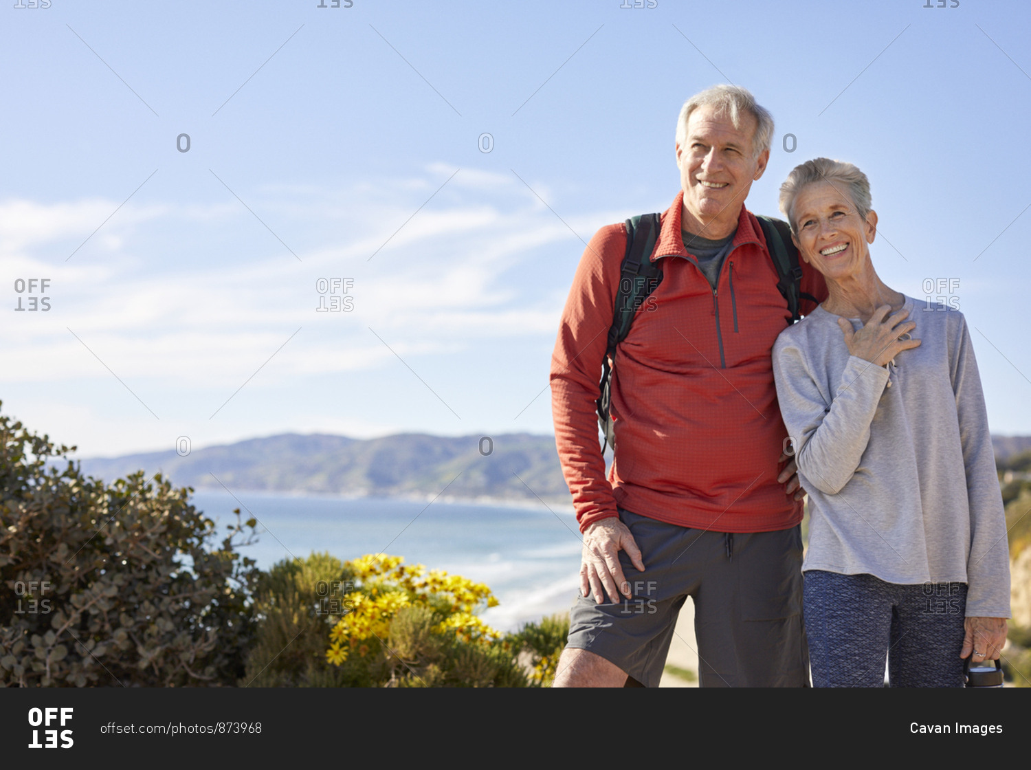Cheerful senior couple standing against sky during sunny day