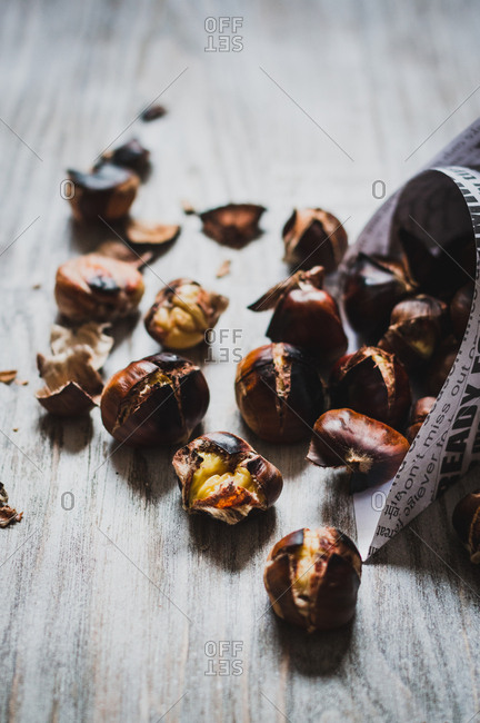 Roasted chestnuts falling out from paper cone