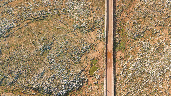 Aerial view of road crossing arid terrain at Balears Island, Spain.