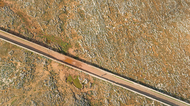 Aerial view of road crossing arid terrain at Balears Island, Spain.