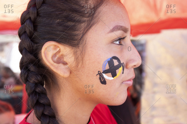 Globe, Arizona, USA - October 3, 2019: Young lady with face painting watching an Apache tribe dancing festival