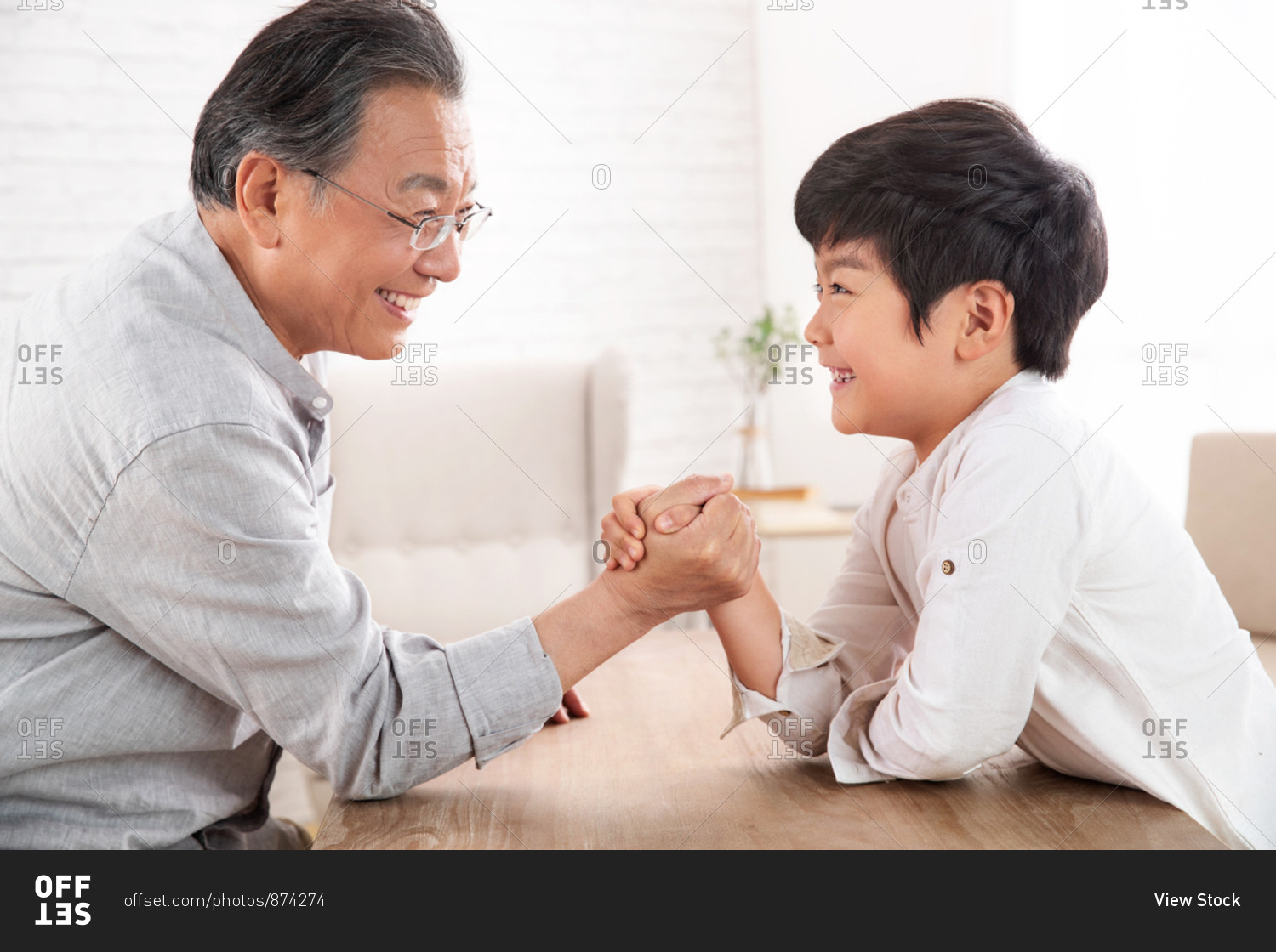 Grandpa and grandson arm-wrestling