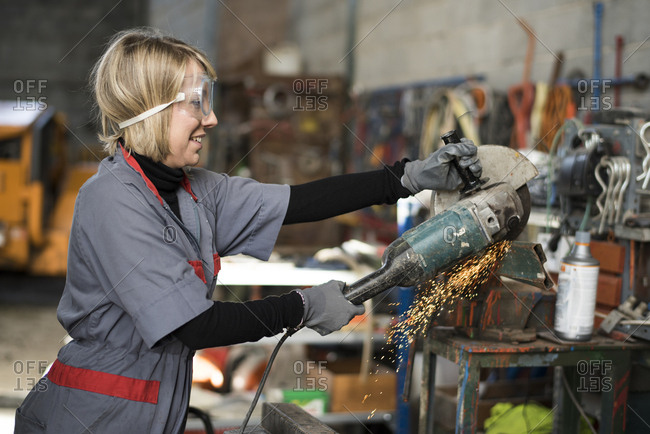 Woman cutting steel with a small buzz saw