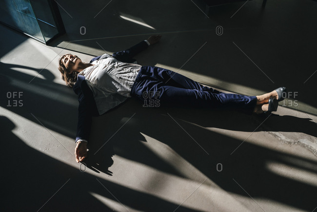 Businesswoman lying on floor in office