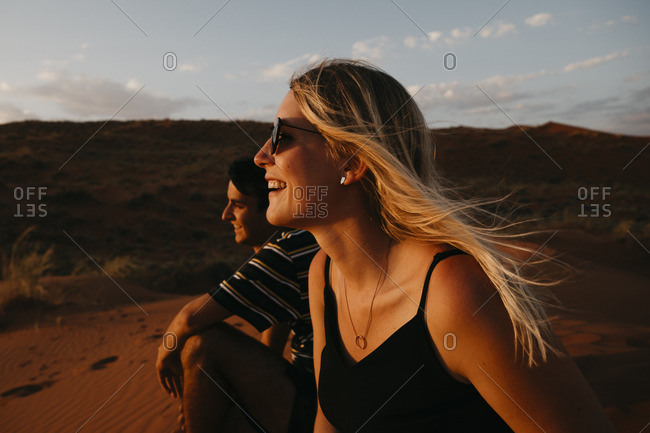 Namibia- Namib desert- Namib-Naukluft National Park- Sossusvlei- happy couple sitting on Elim Dune at sunset