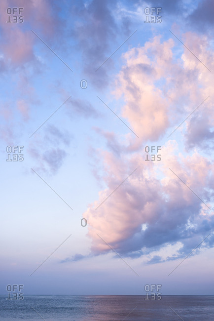 Vertical shot of Cotton Candy pink clouds at sunrise over the ocean