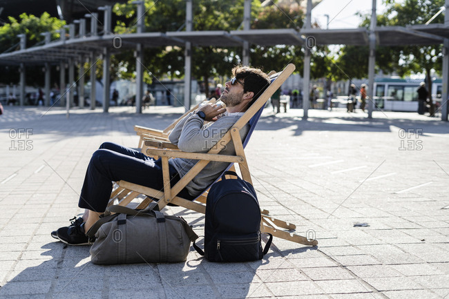 Man relaxing in deckchair on urban square