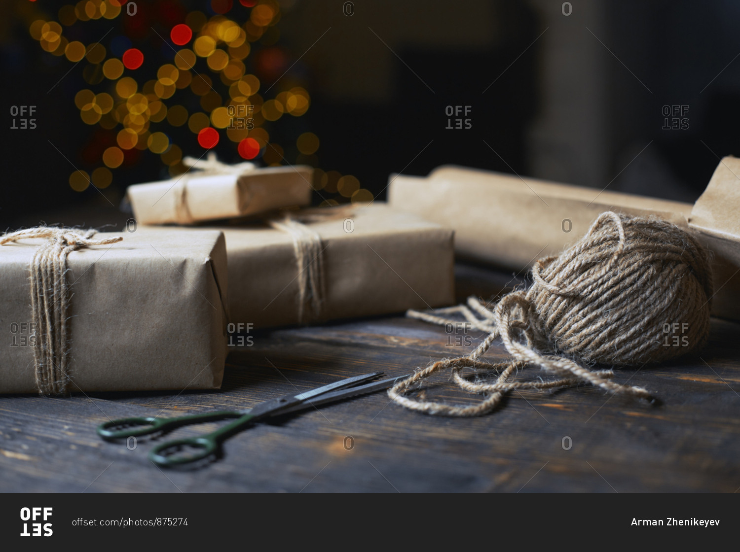 Christmas gift boxes and rope on a wooden table against the Xmas tree