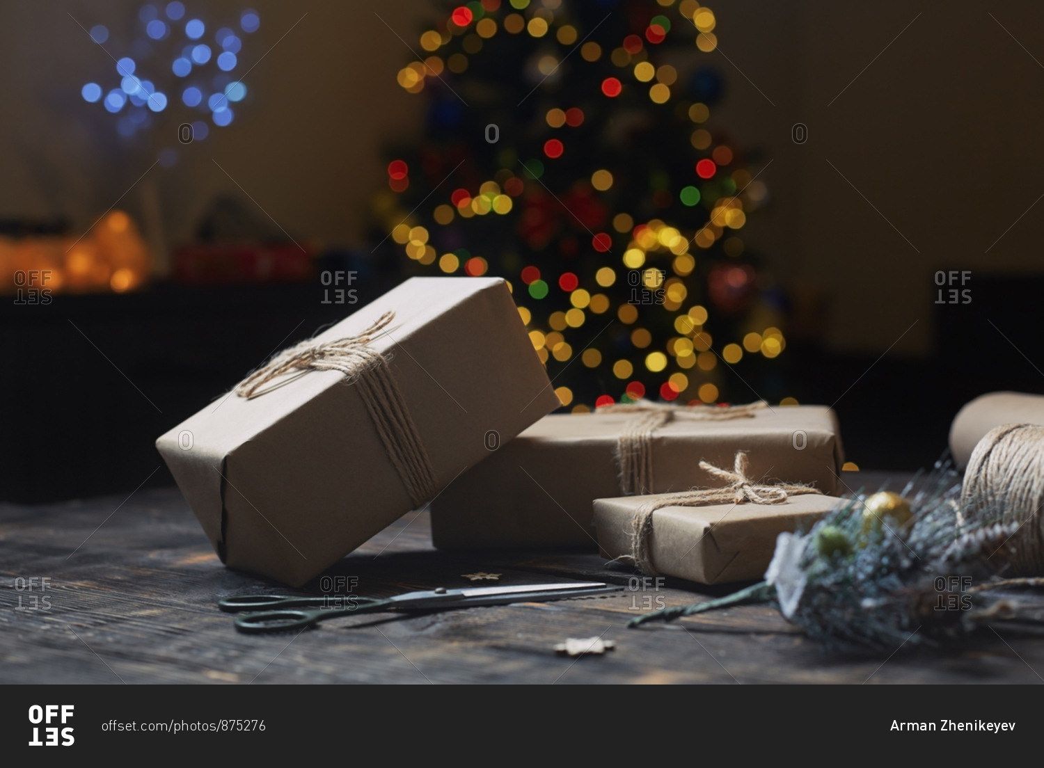 Christmas gift boxes and rope on a wooden table against the Xmas tree
