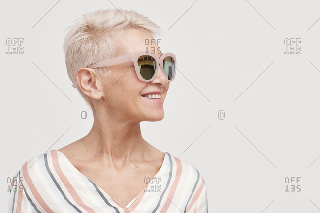 Beautiful middle-aged woman wearing stylish sunglasses looking away horizontal shot