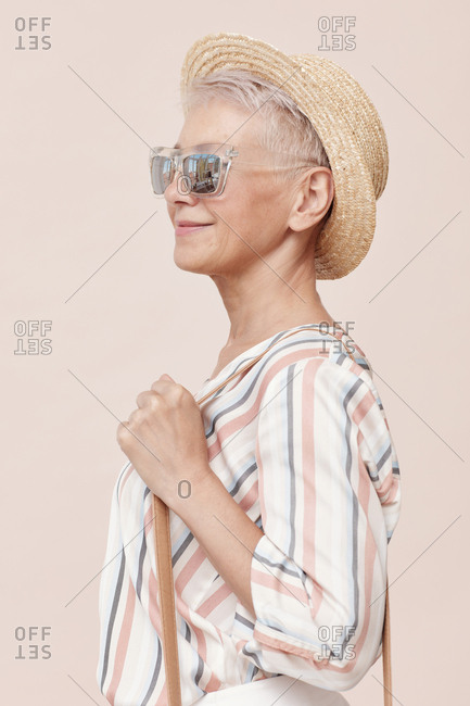 Beautiful mature woman wearing fashionable summer outfit posing on camera