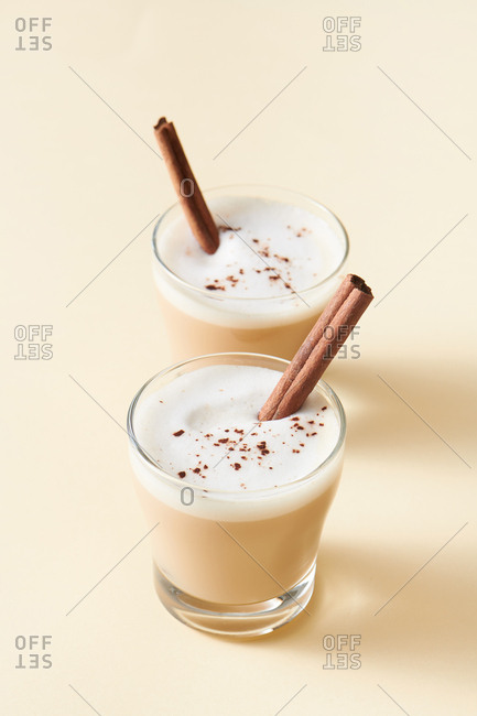Tea latte with cinnamon and anise on solid color background