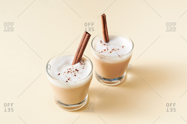 Tea latte with cinnamon and anise on solid color background