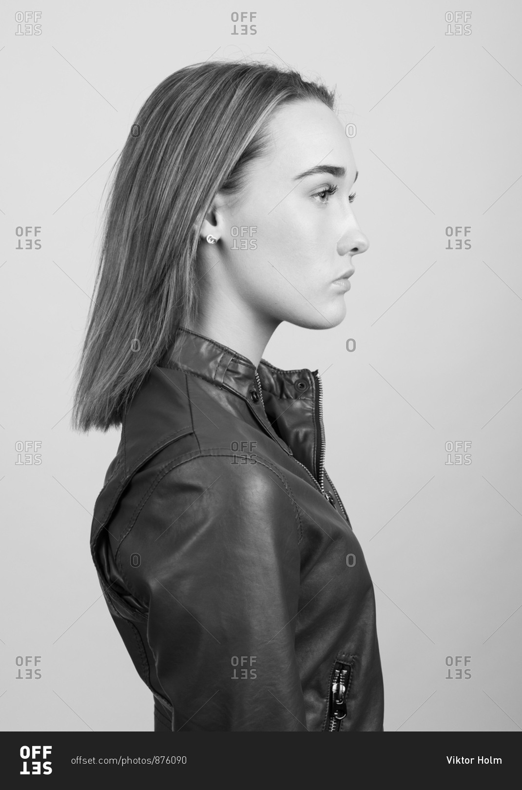 Portrait of a young beautiful fashion model in a leather biker jacket and a  white turtleneck . The concept of women's fashion. Stock Photo